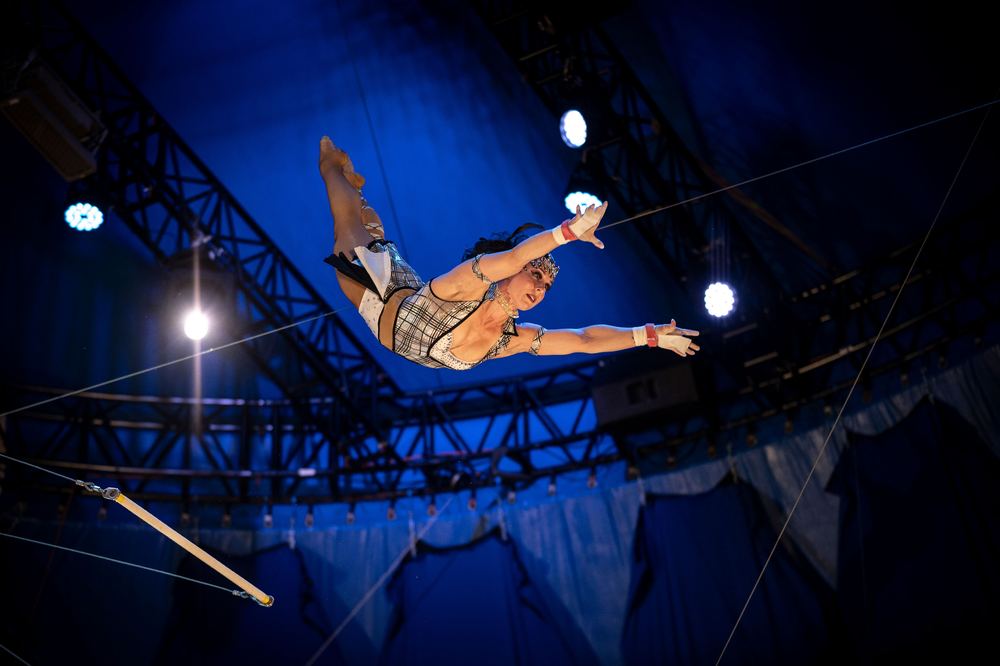 Flying trapeze artist mid-flight