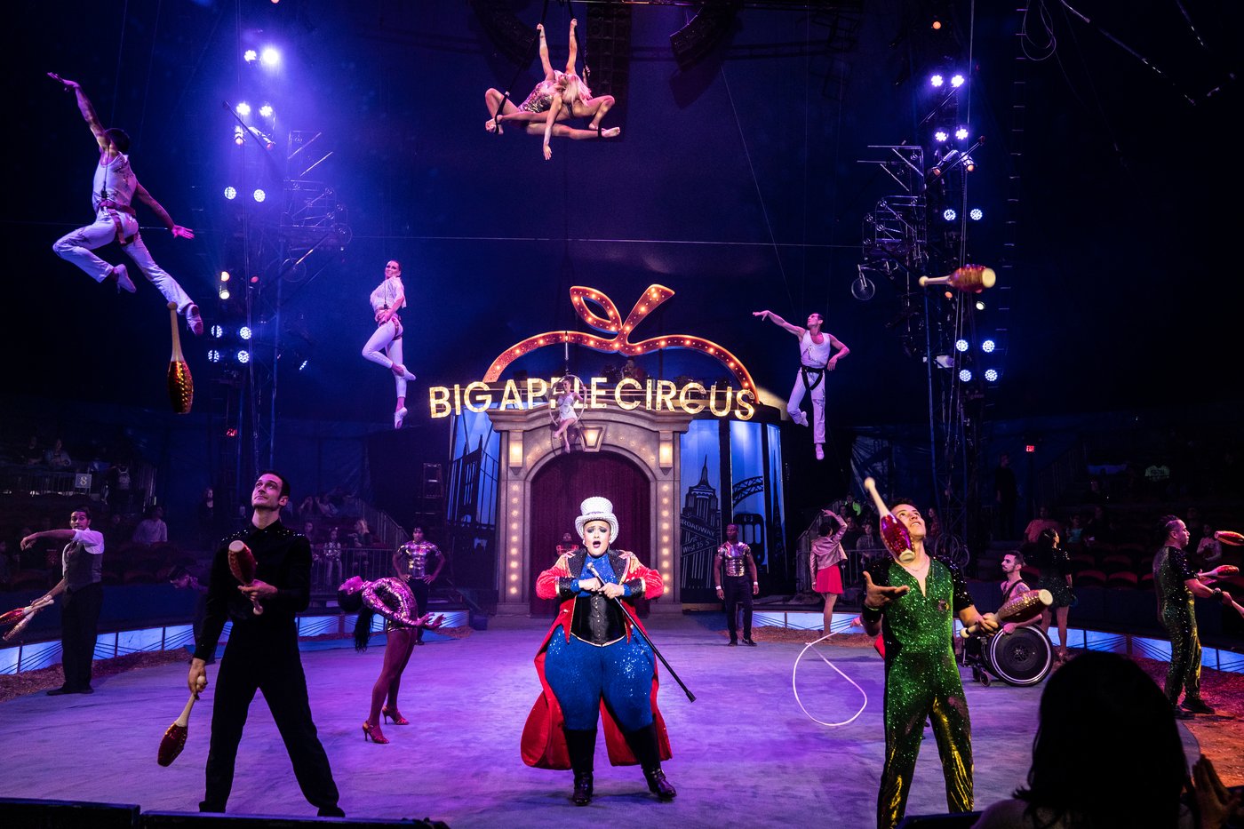 Big Apple Circus — aerial acrobats above the illuminated Big Apple Circus sign